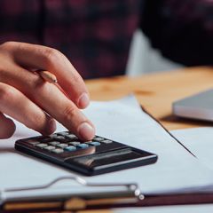 homme travaillant sur ordinateur et calculatrice